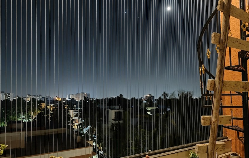 Modern apartment balcony fitted with stainless steel invisible grills for child and pet safety.